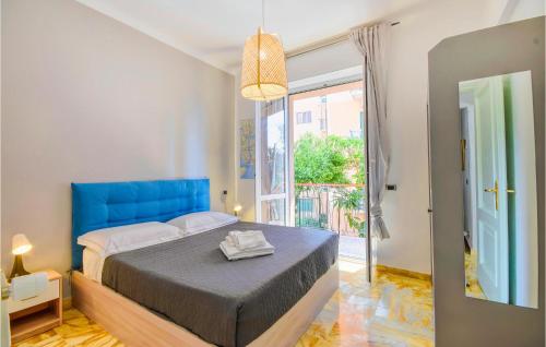 a bedroom with a blue bed and a large window at Lovely Apartment In Genova With Wifi in Genova