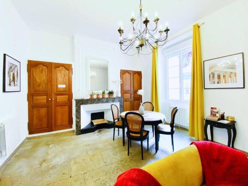 a living room with a table and chairs and a fireplace at L'Occithalie Nîmes Ecusson 2 chambres 72m2 in Nîmes