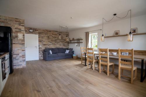 a living room and dining room with a blue couch at Apartmány Pernek in Horní Planá