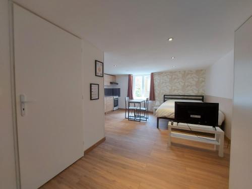 a bedroom with a bed and a table with a television at ° Studio 1 - Lunéville centre ° in Lunéville