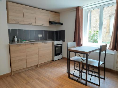 eine Küche mit Holzschränken und einem Tisch mit Stühlen in der Unterkunft ° Studio 1 - Lunéville centre ° in Lunéville