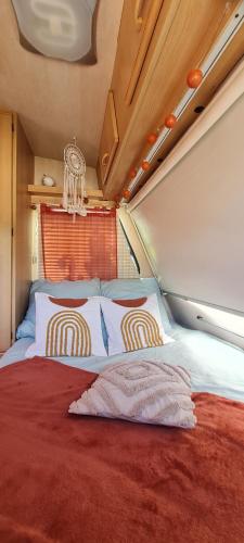 - un lit avec deux oreillers dans une petite chambre dans l'établissement Caravane l'attrape-rêve aux portes du château de Chambord et Cheverny, à Mont-près-Chambord