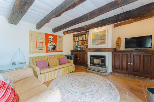 a living room with a couch and a fireplace at Madeira Surf Lodge in São Vicente