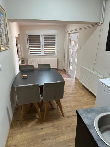 a dining room table and chairs in a kitchen at Odiseja in Kikinda