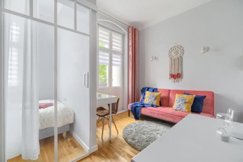 a living room with a red couch and a bed at Fair Point in Poznań