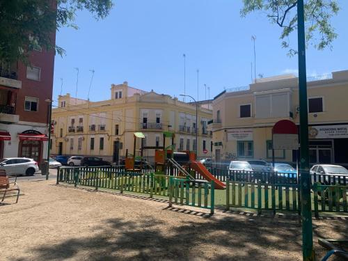 un parc avec une aire de jeux dans une ville dans l'établissement LA CASITA DE LA PUERTA DE CARMONA, à Séville