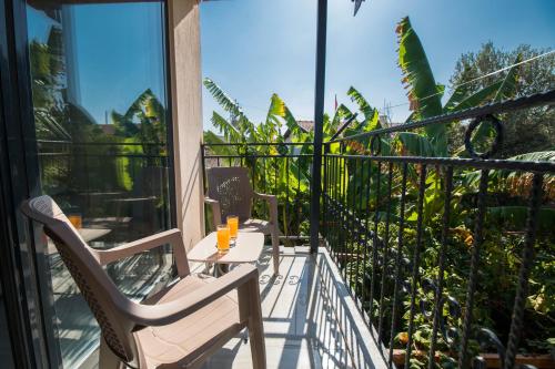 a balcony with two chairs and a table and some plants at Beyoglu Pansiyon in Patara