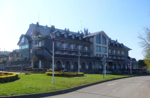 a large building on the side of a street at Hotel Milagros Golf in Mogro
