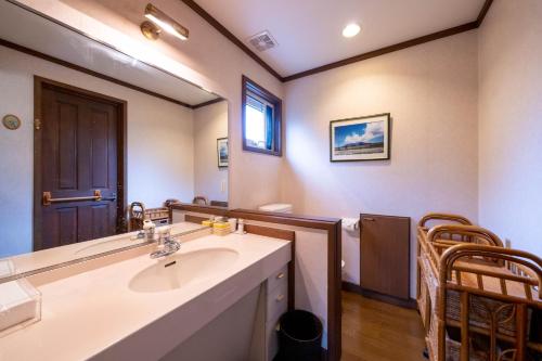 ein Bad mit einem Waschbecken und einem Spiegel in der Unterkunft スイートヴィラ アンジュール 小淵沢高原 in Iwa-kubo