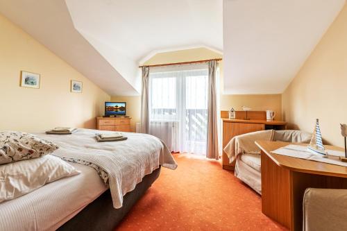 um quarto de hotel com duas camas e uma janela em Róża Wiatrów em Władysławowo