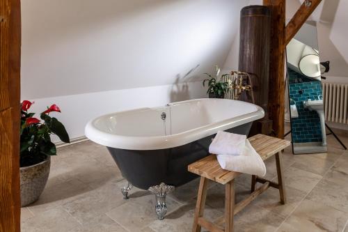 a clawfoot bathtub in a bathroom with plants at Podenhaus in Bad Aussee