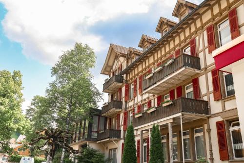 - un bâtiment avec des balcons sur le côté dans l'établissement Parkhotel Beatenberg, à Beatenberg