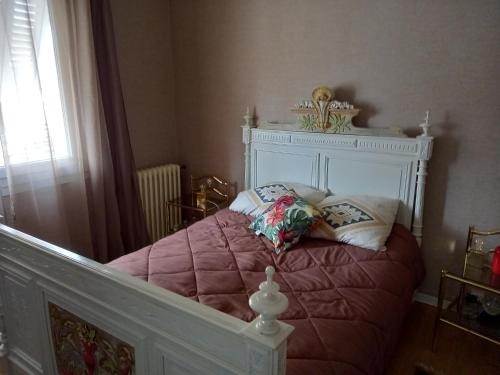 - un petit lit avec une couverture rose et des oreillers dans l'établissement ADOUR FETES ET PLAISIRS, à Aureilhan