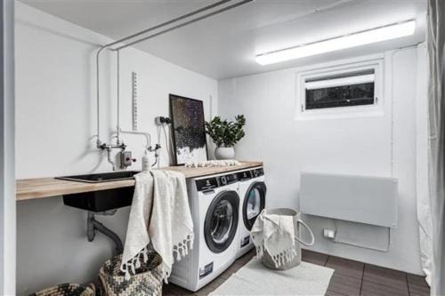a kitchen with a washing machine and a sink at Kullavik, 2 mil från Göteborg Villa Gläntan in Kullavik