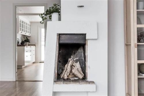 a white fireplace in a white living room at Kullavik, 2 mil från Göteborg Villa Gläntan in Kullavik