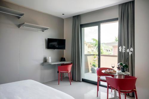 a bedroom with red chairs and a table and a window at Ollen apartments in Catania