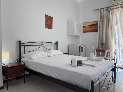 1 dormitorio con 1 cama con 2 toallas en Λεμονιά Ενοικιαζόμενα δωμάτια, en Loutra Edipsou