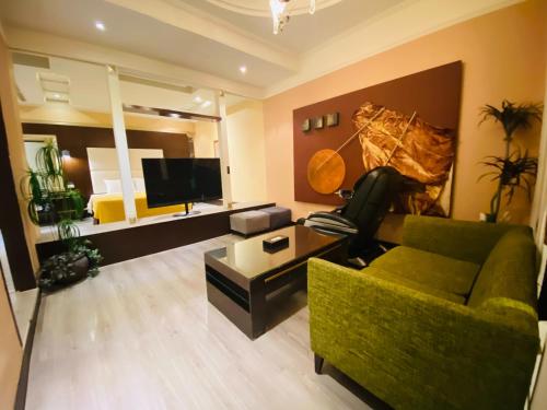 a living room with a green couch and a television at Holland Hill Motel in Tainan