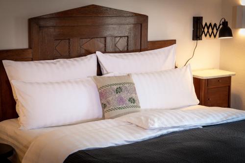 a bed with white pillows and a wooden headboard at Podenhaus in Bad Aussee