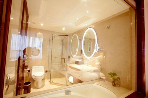 a bathroom with a tub and a toilet and a sink at Xian heng Hotel in Shaoxing