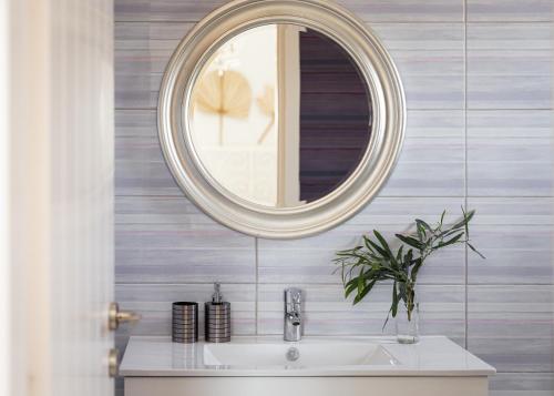 a bathroom with a sink and a mirror at Paros House Villa in Pounda