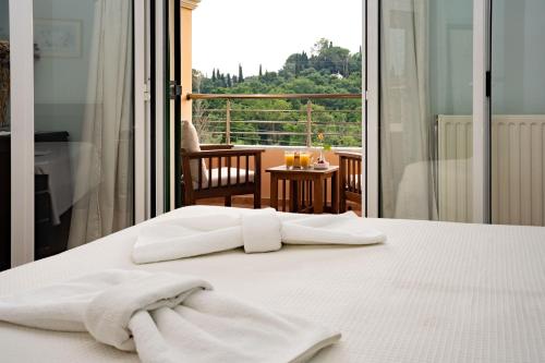 two towels on a bed in front of a balcony at La Bella Vita - Luxury Holiday House close to Corfu Town in Potamós