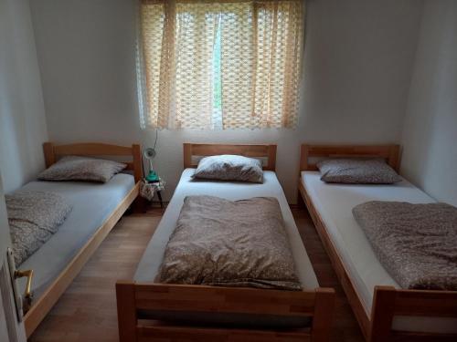 two twin beds in a room with a window at Seosko domaćinstvo Vidović in Banja Luka