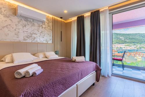 a bedroom with a large bed with towels on it at Villa Lavanda in Cres