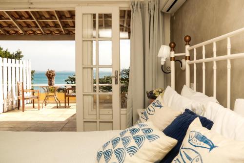 a bedroom with a bed and a view of the ocean at Pousada Baía Bonita in Búzios