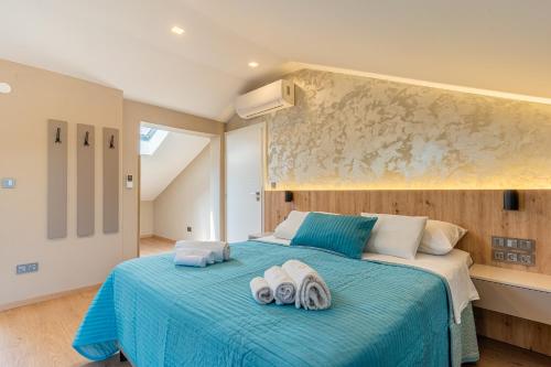 a bedroom with two towels on a blue bed at Villa Lavanda in Cres