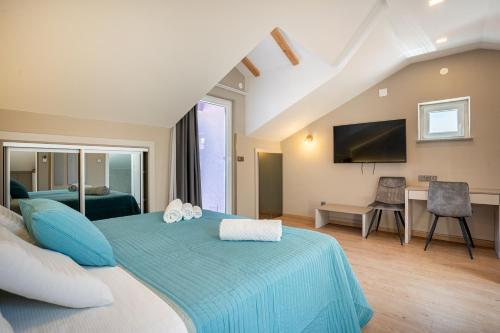 um quarto com uma cama azul e uma televisão em Villa Lavanda em Cres