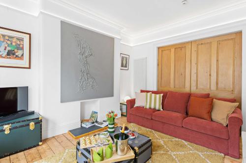 a living room with a red couch and a tv at Hoe Park House, Sleeps 10, Historic, Central, Near Excellent Dining, Bars & Seafront in Plymouth