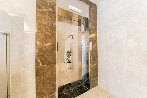 a shower with a glass door in a bathroom at Hotel Orayeon in Yeongwol