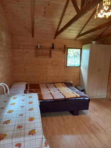 a bedroom with two beds in a wooden cabin at Słoneczne Zbocze in Wysowa-Zdrój