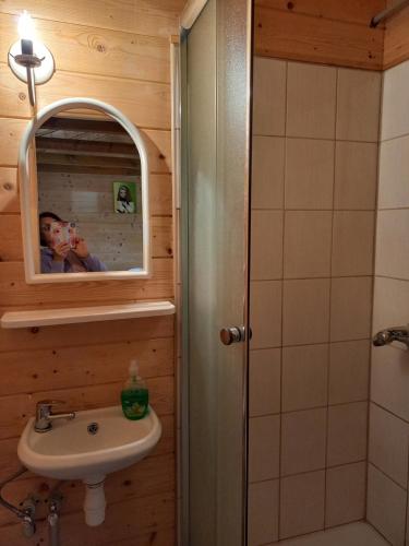 un uomo che scatta una foto di un bagno con lavandino di Słoneczne Zbocze a Wysowa-Zdrój