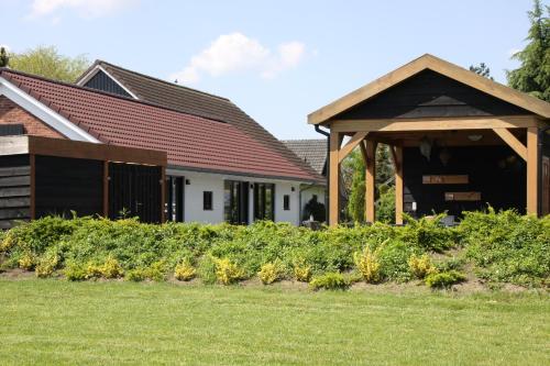 a garden in front of a house with a pavilion at B&B Hoeve de Veldmaat in Haaksbergen