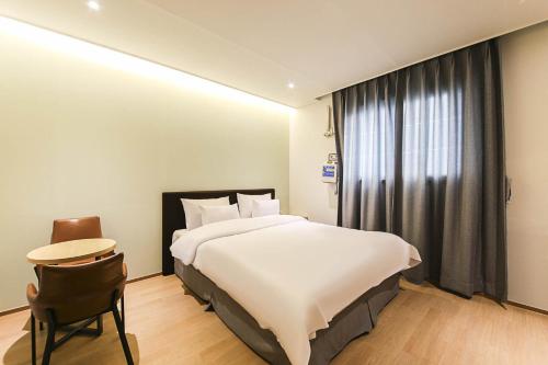 a bedroom with a large white bed and a window at 어라연 관광호텔 영월 in Yeongwol