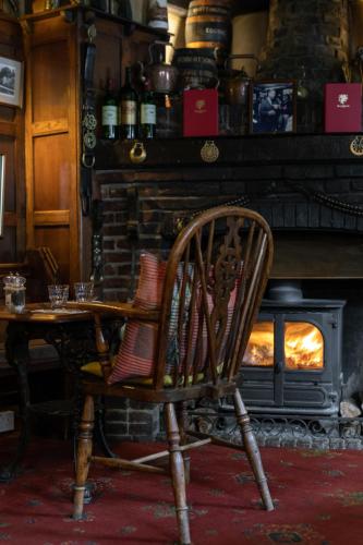 a wooden chair sitting in front of a fireplace at The Griffin Inn in Fletching