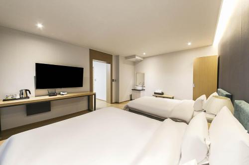 a hotel room with two beds and a flat screen tv at 어라연 관광호텔 영월 in Yeongwol
