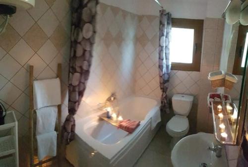 a bathroom with a tub and a toilet and a sink at Byron House in Parga