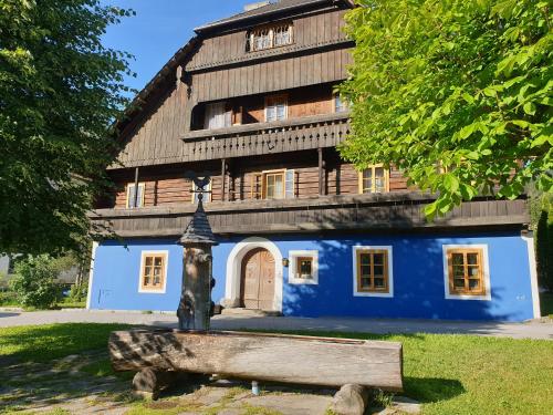 un gran edificio azul con una estatua delante de él en Blue House, en Ramingstein