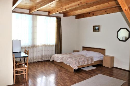 a bedroom with a bed and a desk and a window at Taoskari Hotel in Vardzia