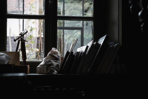 a pile of books sitting in front of a window at pieuX in Montreuil-sur-Mer