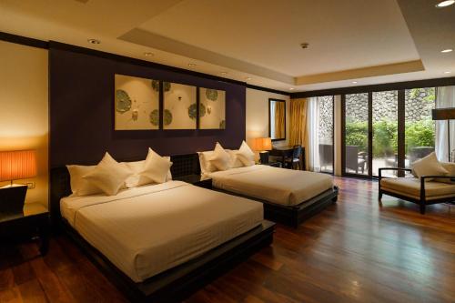 Pokój hotelowy z 2 łóżkami i krzesłem w obiekcie 2 Bedrooms Beachfront Pool Villas w mieście Bang Tao Beach