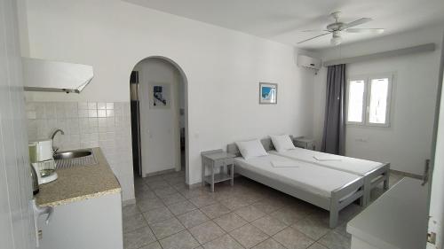 a white room with a bed and a sink at Marianos Apartments in Antiparos