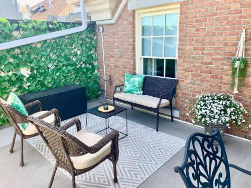 a patio with chairs and a table and a couch at Suites On King in Niagara on the Lake