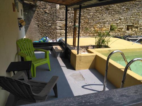 une terrasse avec une chaise verte et une piscine dans l'établissement Zoé, à Chervettes