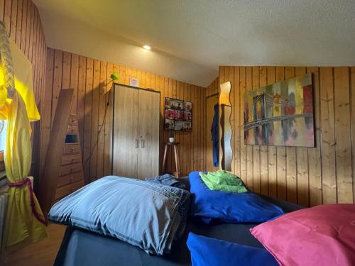 two beds in a room with wooden walls at Corps Au Coeur in Montana