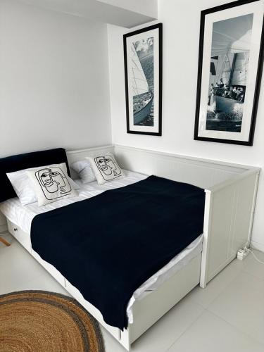 a white bedroom with a black and white bed at Oxygen studio in Jupiter