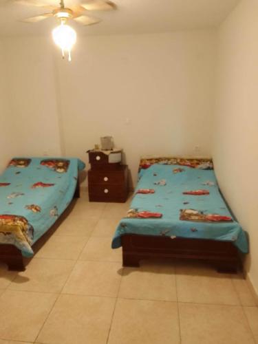 a bedroom with two beds and a night stand at Akrotirio Tainaro House in Marmari